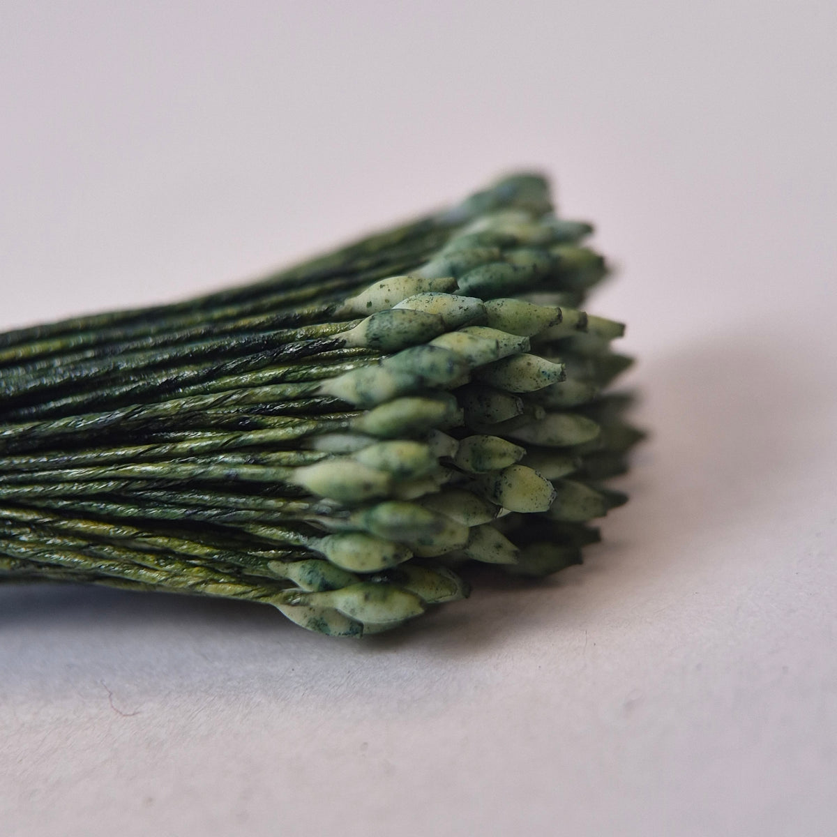 Miniature green elongated flower stamens size S on matching green cotton threads, premium Japanese floral supplies