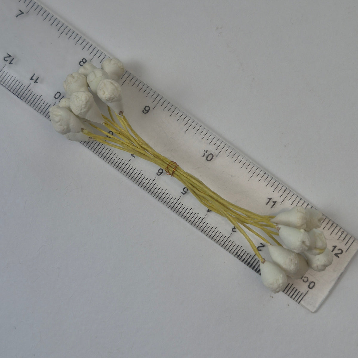A bundle of 10 flexible yellow wire stems with 20 white closed decorative Japanese flower buds
