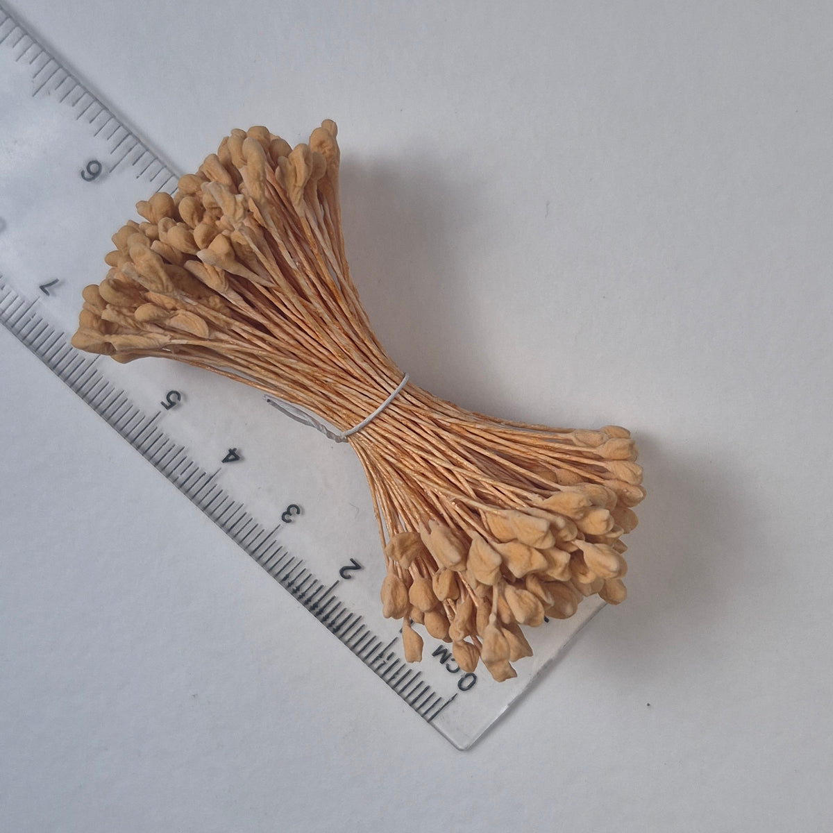 A bundle of extra-large size XL naturalistic Japanese flower stamens, featuring soft beige droplet-shaped heads on matching beige rayon threads