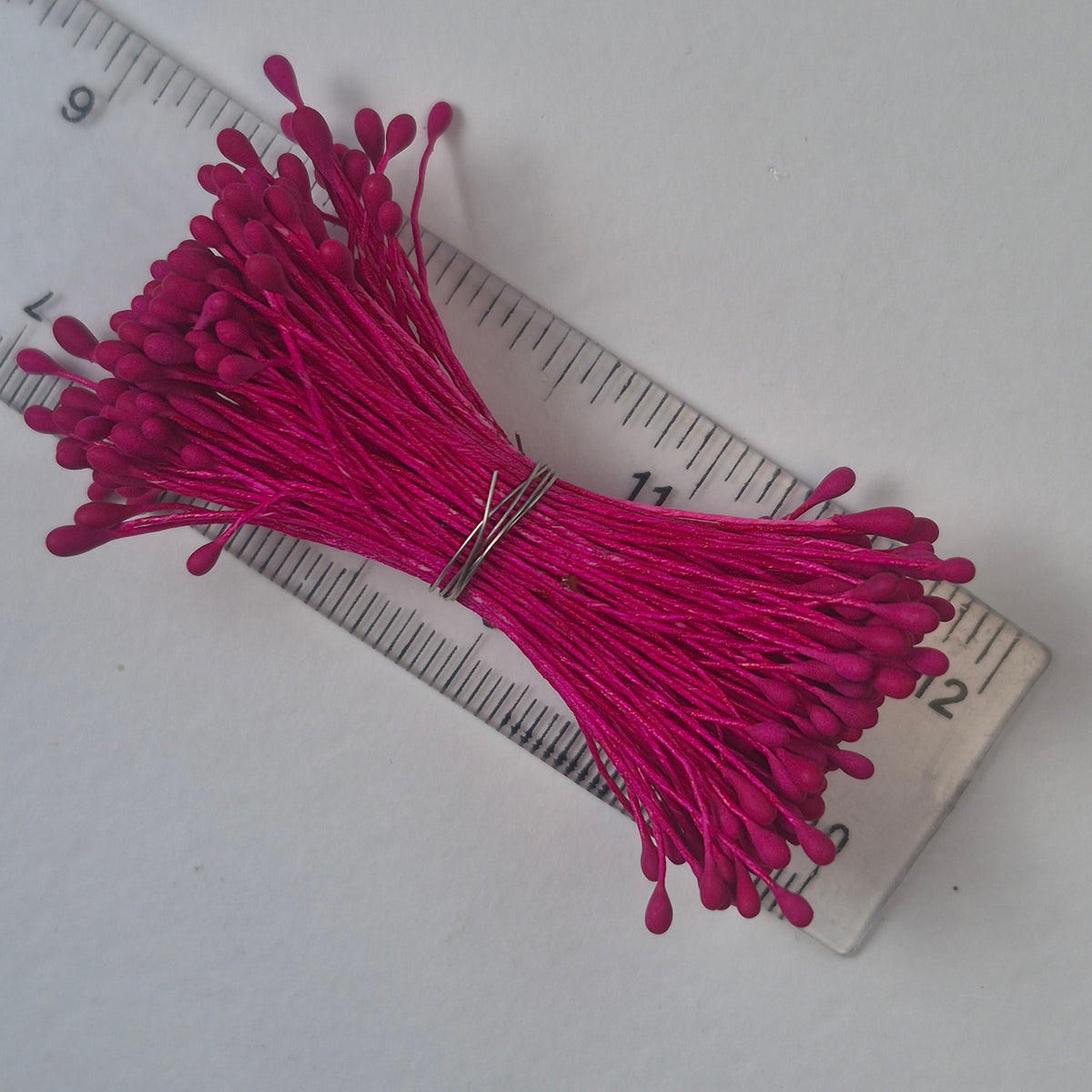 A bundle of size L Japanese flower stamens, featuring vibrant raspberry droplet-shaped heads on matching raspberry cotton threads