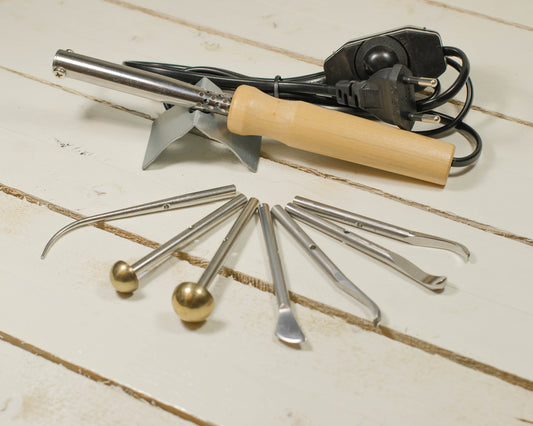 Set of metal fabric flower making tools with wooden handle on a light wooden surface