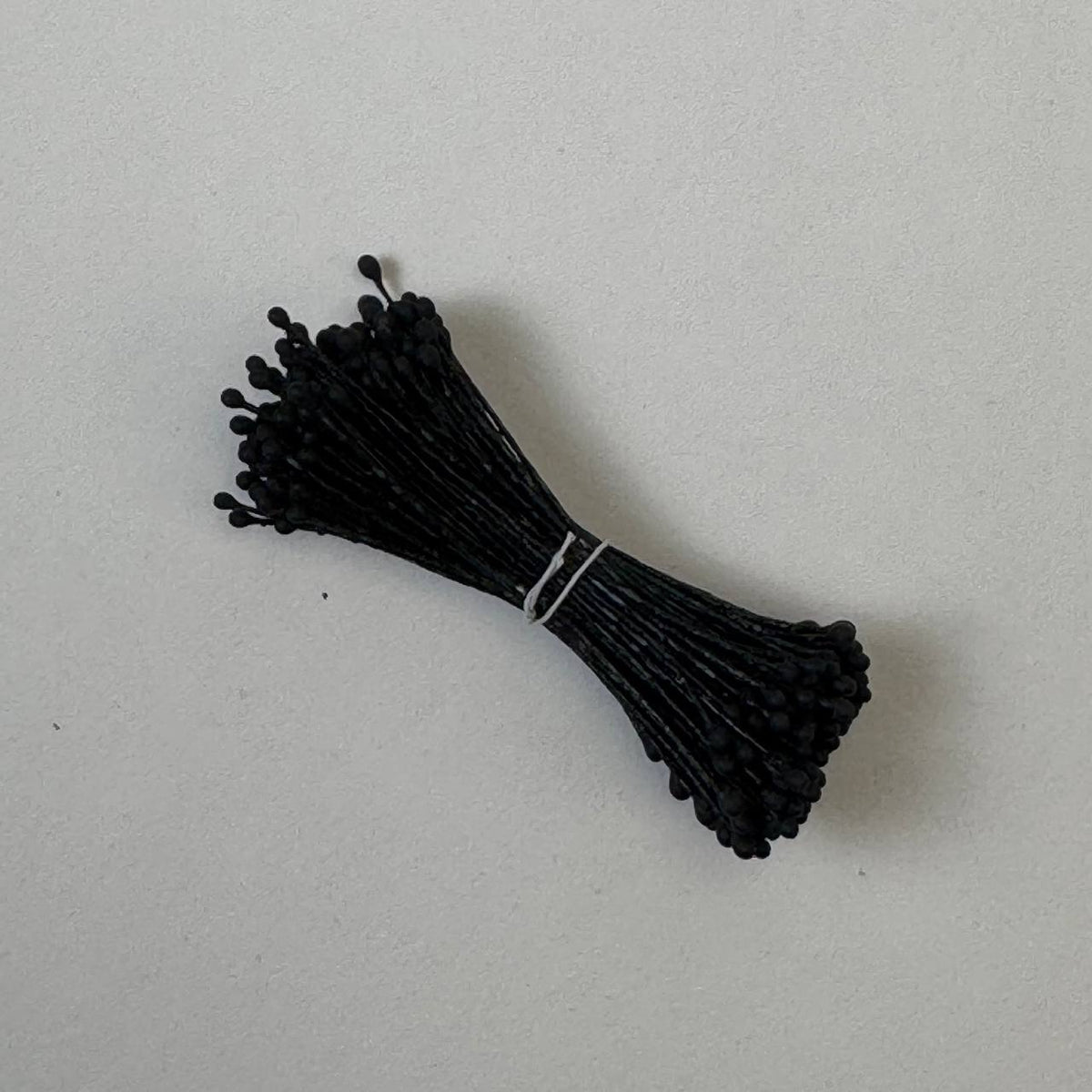 Black naturalistic flower stamens size L with botanical shapes on matching black cotton threads, bundle of 144 pieces, premium Japanese floral supplies.