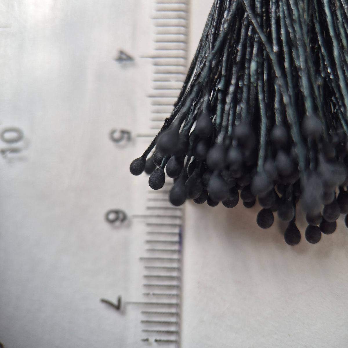 Black naturalistic flower stamens size L with botanical shapes on matching black cotton threads, bundle of 144 pieces, premium Japanese floral supplies.