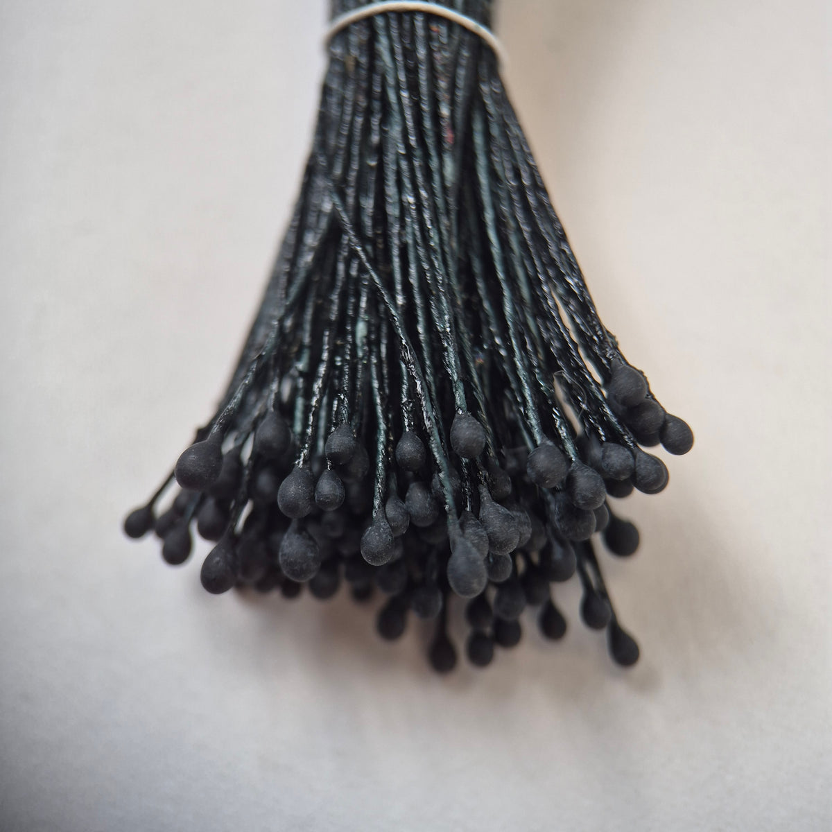 Black naturalistic flower stamens size L with botanical shapes on matching black cotton threads, bundle of 144 pieces, premium Japanese floral supplies.