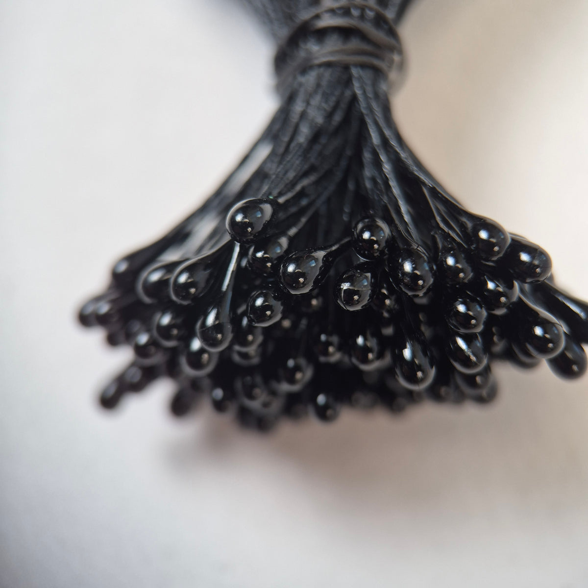 Black pearl flower stamens size L with glossy finish on matching black cotton threads, bundle of 144 pieces, premium Japanese floral supplies