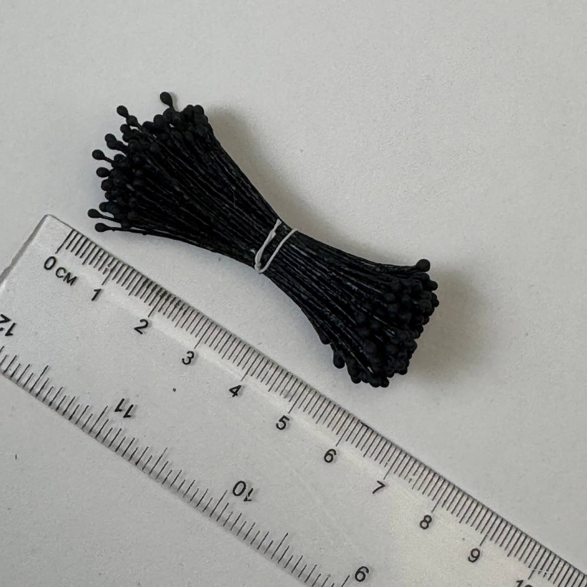 Black naturalistic flower stamens size L with botanical shapes on matching black cotton threads, bundle of 144 pieces, premium Japanese floral supplies.