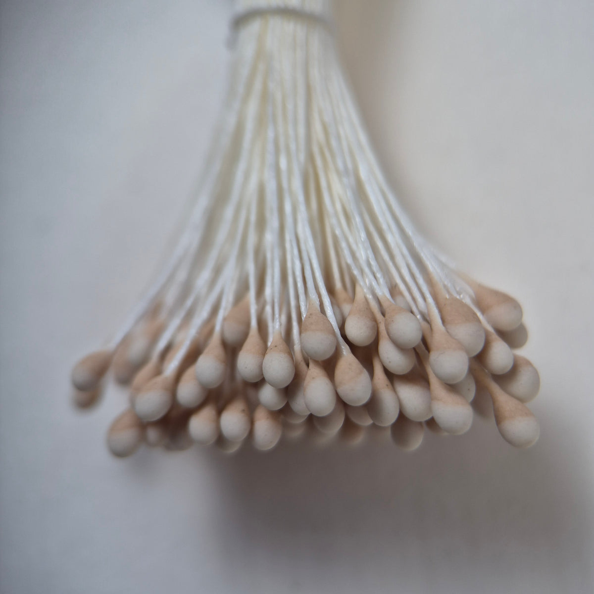 Two-tone beige and white naturalistic flower stamens size L with botanical shapes on white cotton threads, bundle of 144 pieces, premium Japanese floral supplies.