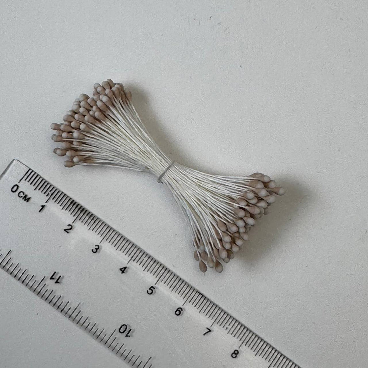 Two-tone beige and white naturalistic flower stamens size L with botanical shapes on white cotton threads, bundle of 144 pieces, premium Japanese floral supplies.