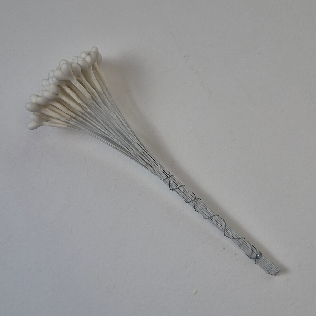 A bundle of 36 single-sided white decorative Japanese stamens on flexible 13cm white wire stems, featuring large heads with three droplets fused into a single stamen