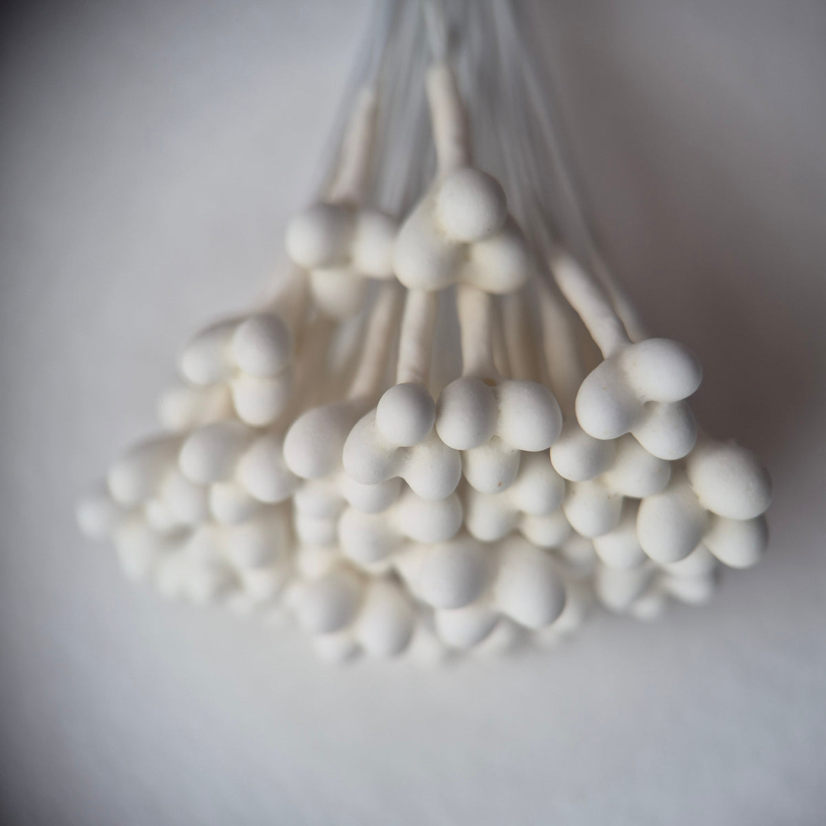 A bundle of 36 single-sided white decorative Japanese stamens on flexible 13cm white wire stems, featuring large heads with three droplets fused into a single stamen