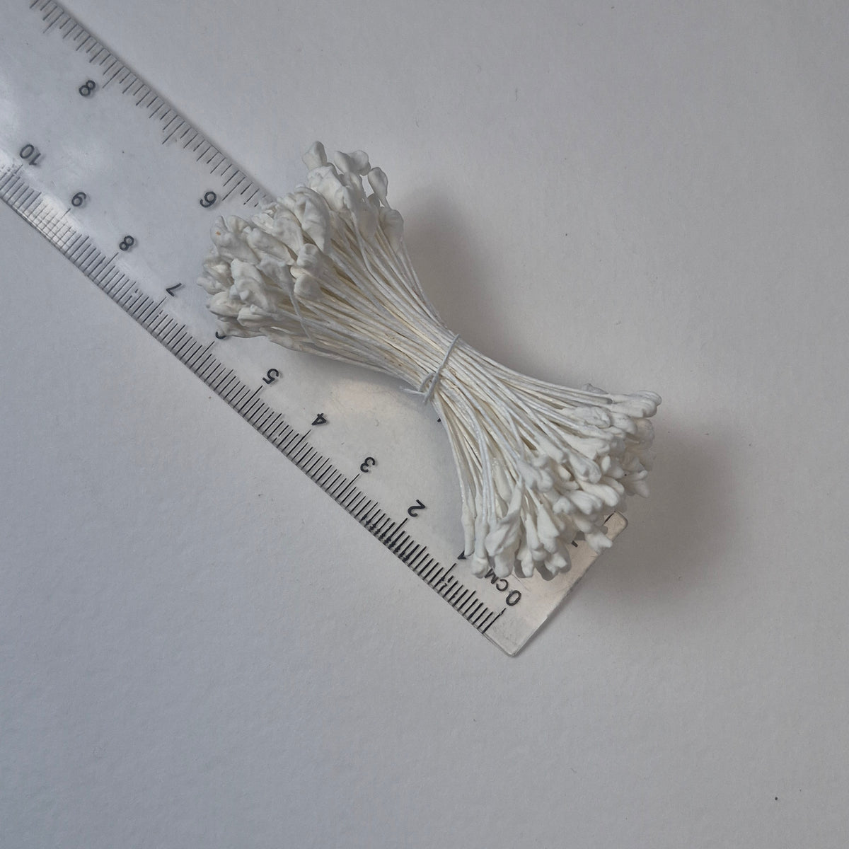 A bundle of extra-large size XL naturalistic Japanese flower stamens, featuring classic white droplet-shaped heads on matching white rayon threads
