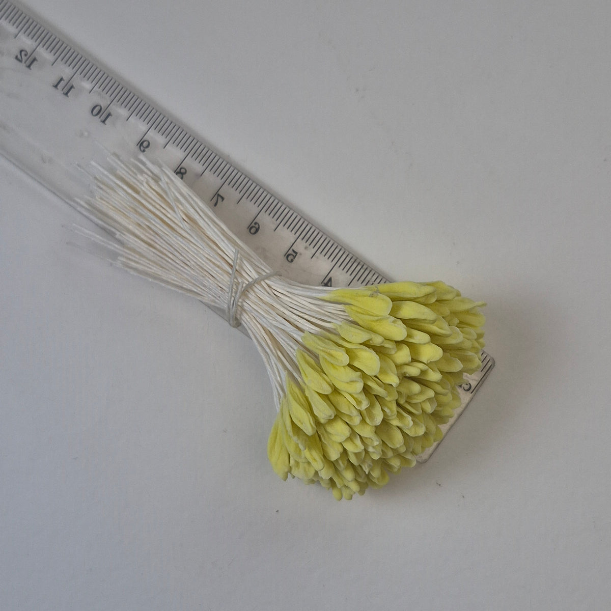 A bundle of 144 single-sided extra-large size XL yellow decorative Japanese flower stamens for lilies and tulips on white threads, featuring large handmade elongated heads measured against a ruler