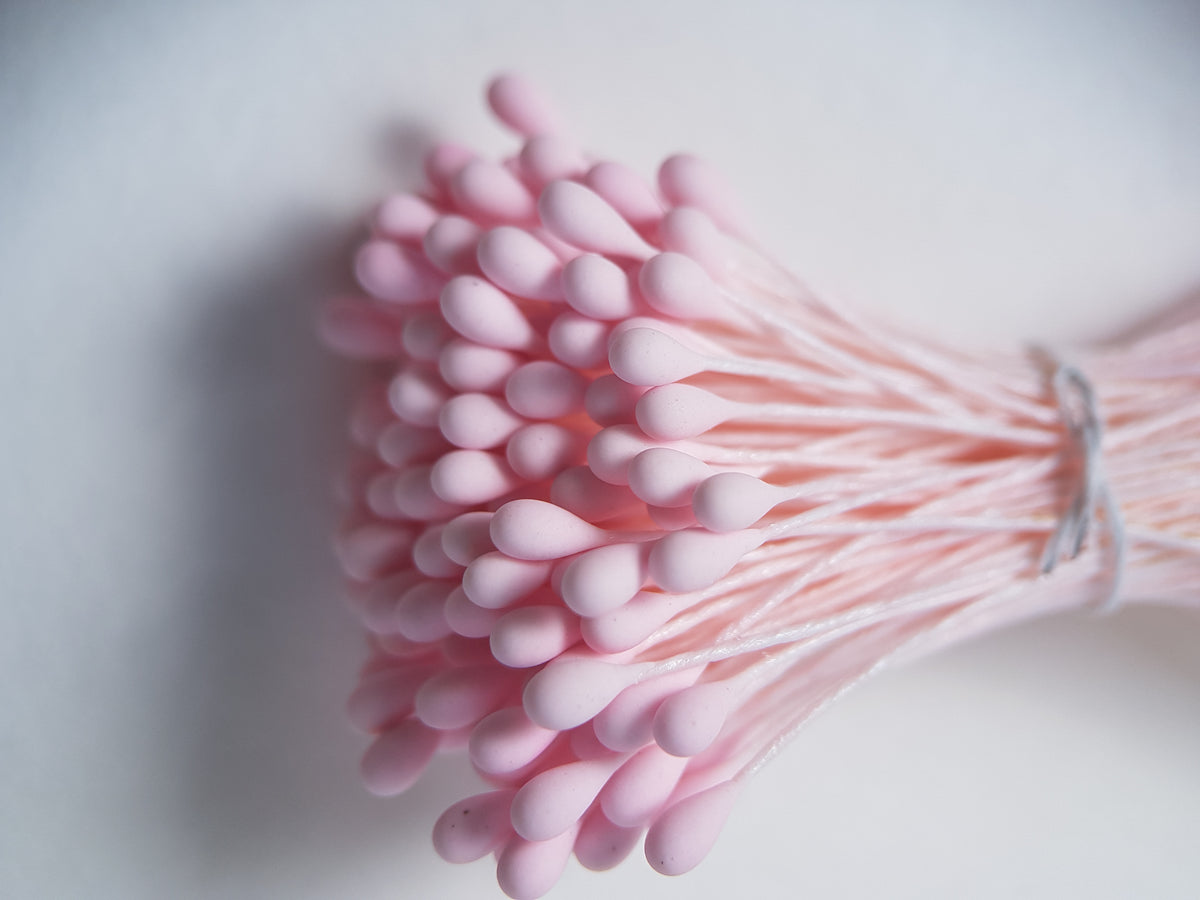 A bundle of size L Japanese flower stamens, featuring vibrant pink droplet-shaped heads on matching pink cotton threads.
