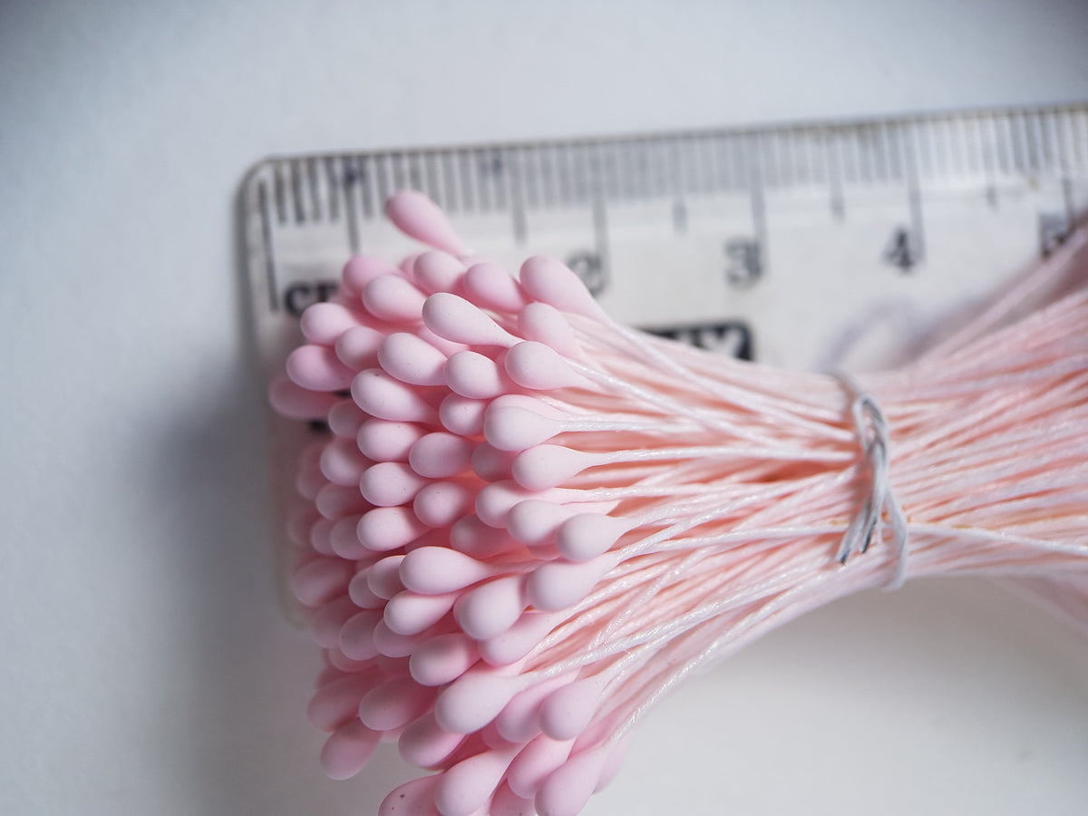 A bundle of size L Japanese flower stamens, featuring vibrant pink droplet-shaped heads on matching pink cotton threads.
