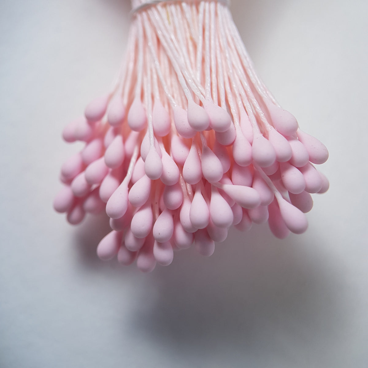 A bundle of size L Japanese flower stamens, featuring vibrant pink droplet-shaped heads on matching pink cotton threads.