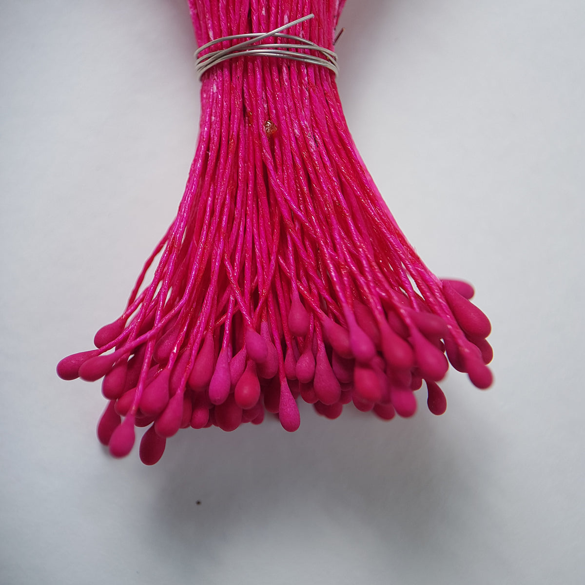 A bundle of size L Japanese flower stamens, featuring vibrant raspberry droplet-shaped heads on matching raspberry cotton threads