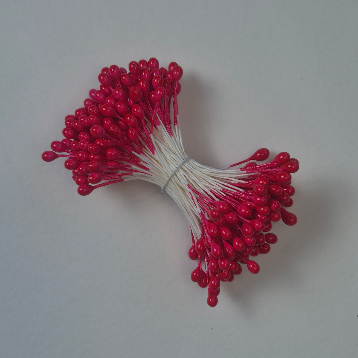 A bundle of size L Japanese flower stamens, featuring vibrant red round heads on white cotton threads.