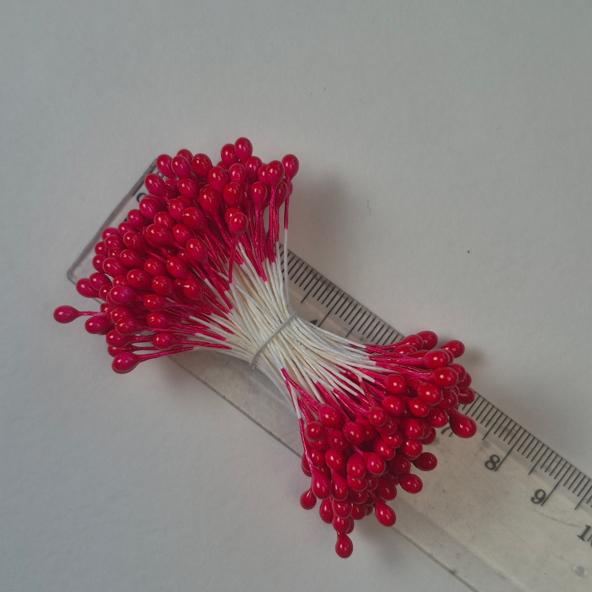 A bundle of size L Japanese flower stamens, featuring vibrant red round heads on white cotton threads.