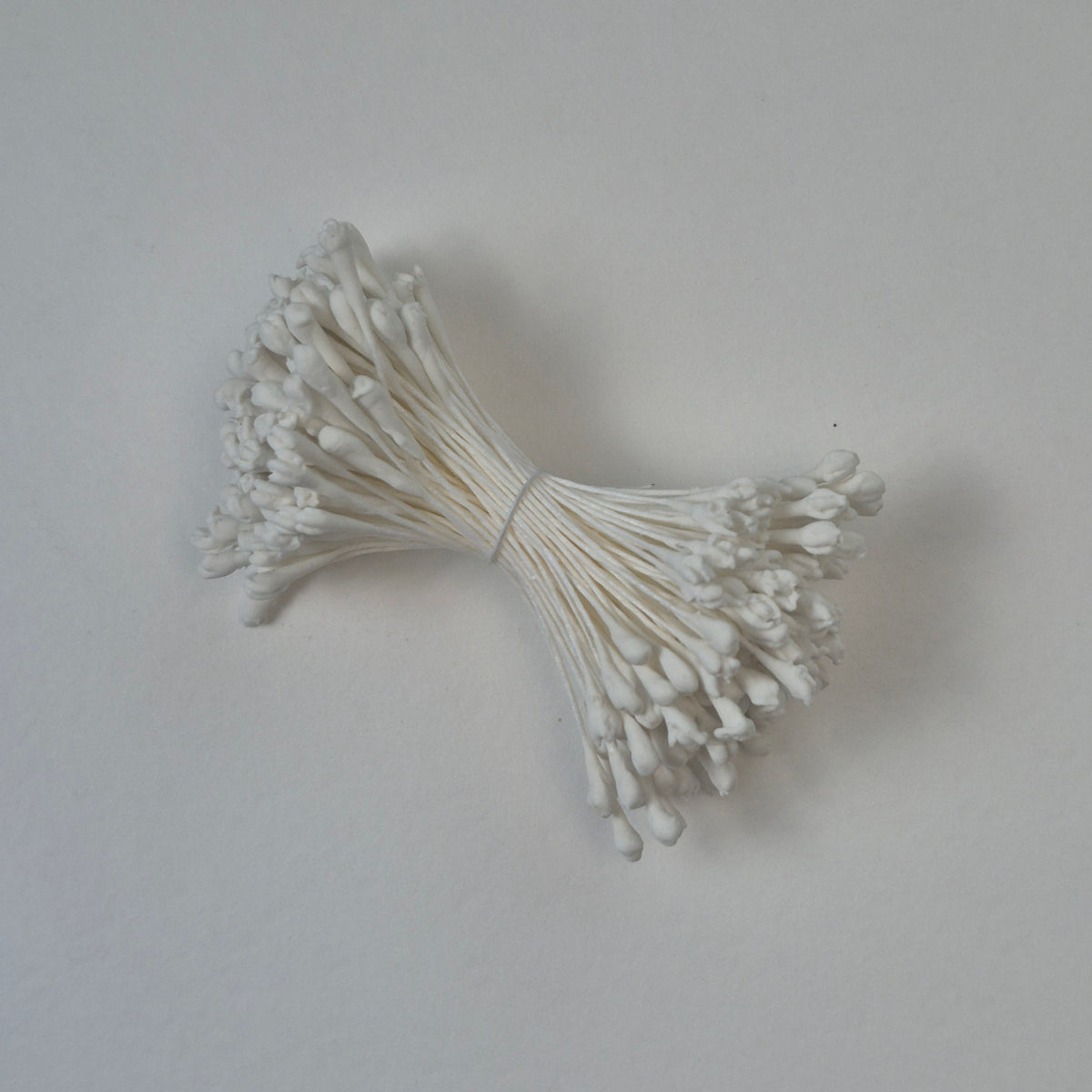A bundle of extra-large size XL naturalistic Japanese flower stamens made of white rice flour and rayon threads, arranged next to a transparent ruler