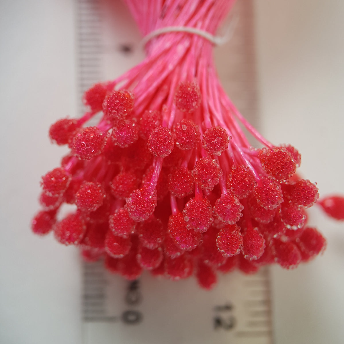 A bundle of size XL Japanese bright pink sugar ball flower stamens made of rice flour and matching pink rayon threads, featuring 5mm frosted textured round heads next to a ruler