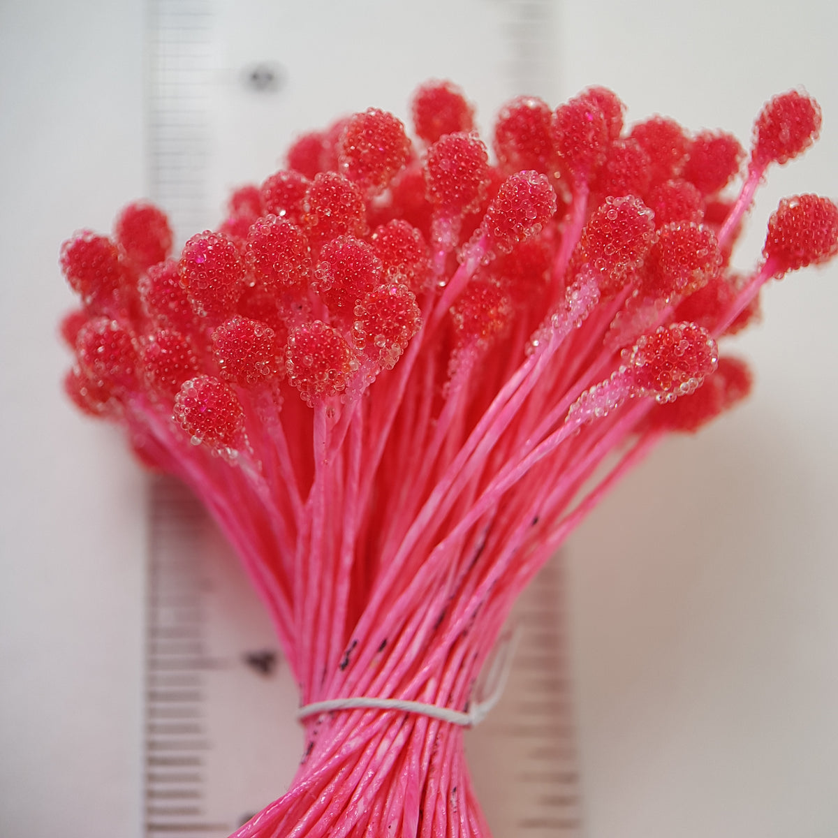 A bundle of size XL Japanese bright pink sugar ball flower stamens made of rice flour and matching pink rayon threads, featuring 5mm frosted textured round heads next to a ruler