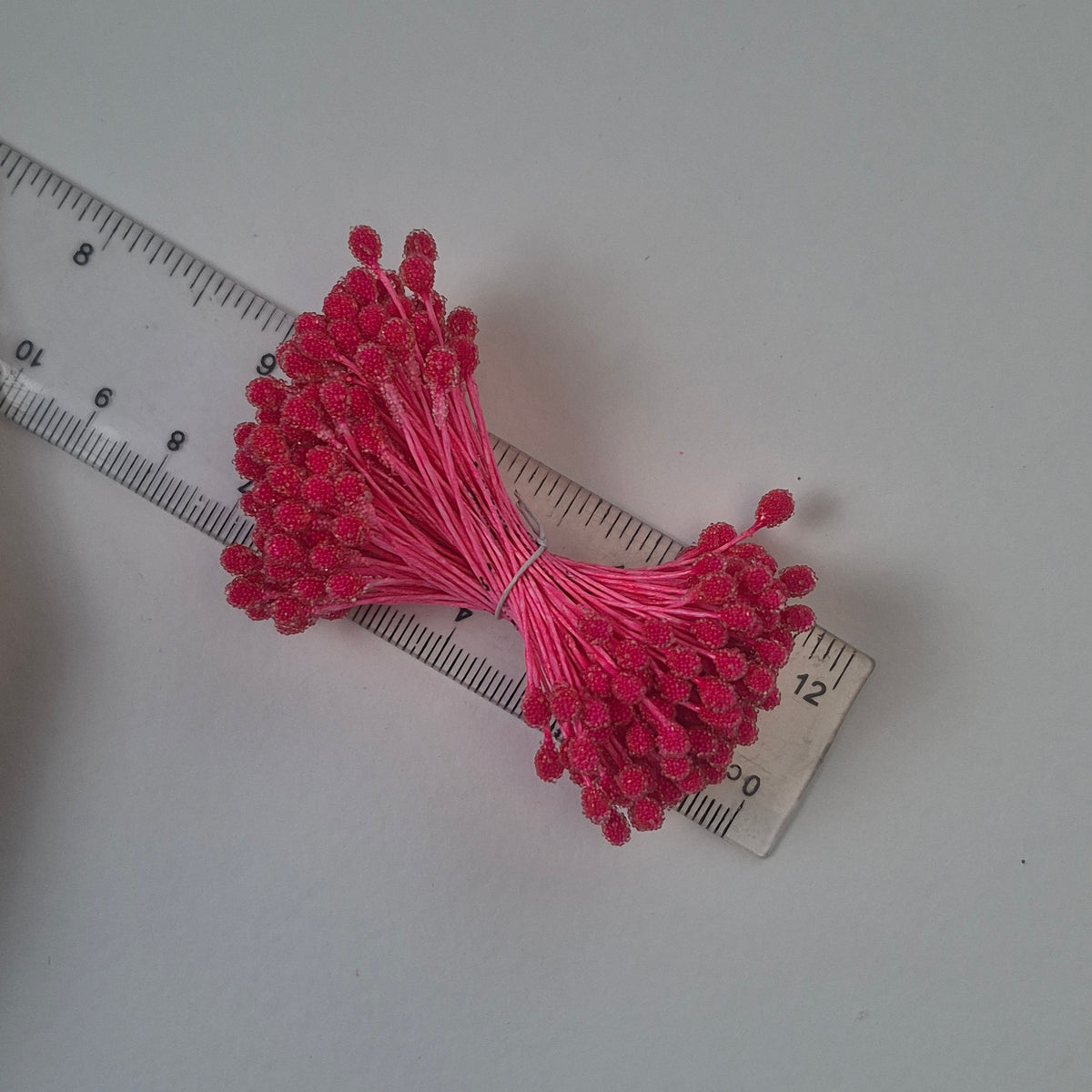 A bundle of size XL Japanese bright pink sugar ball flower stamens made of rice flour and matching pink rayon threads, featuring 5mm frosted textured round heads next to a ruler