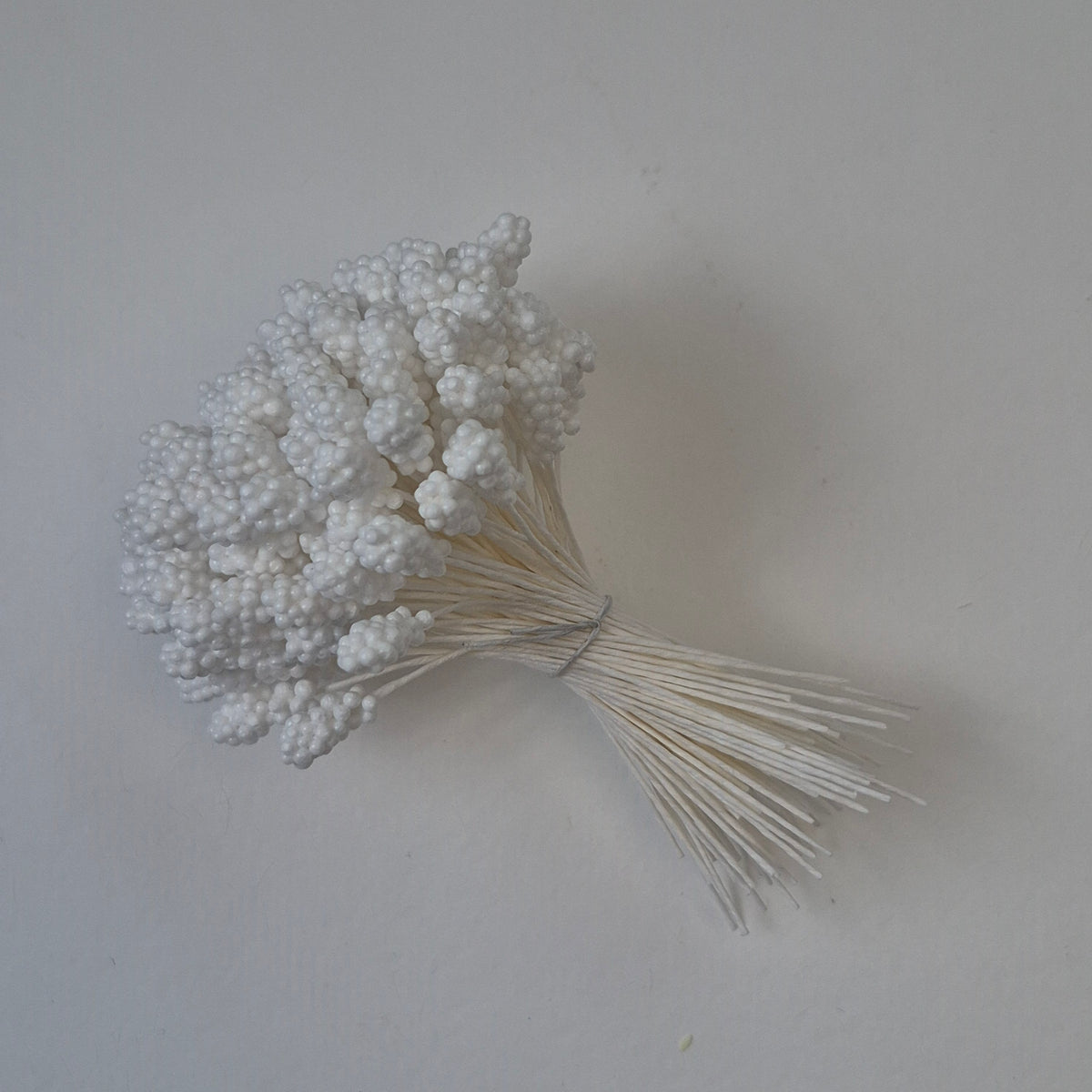 A bundle of 144 single-sided textured Japanese flower stamens with white gypsophila-effect heads on matching white rayon threads