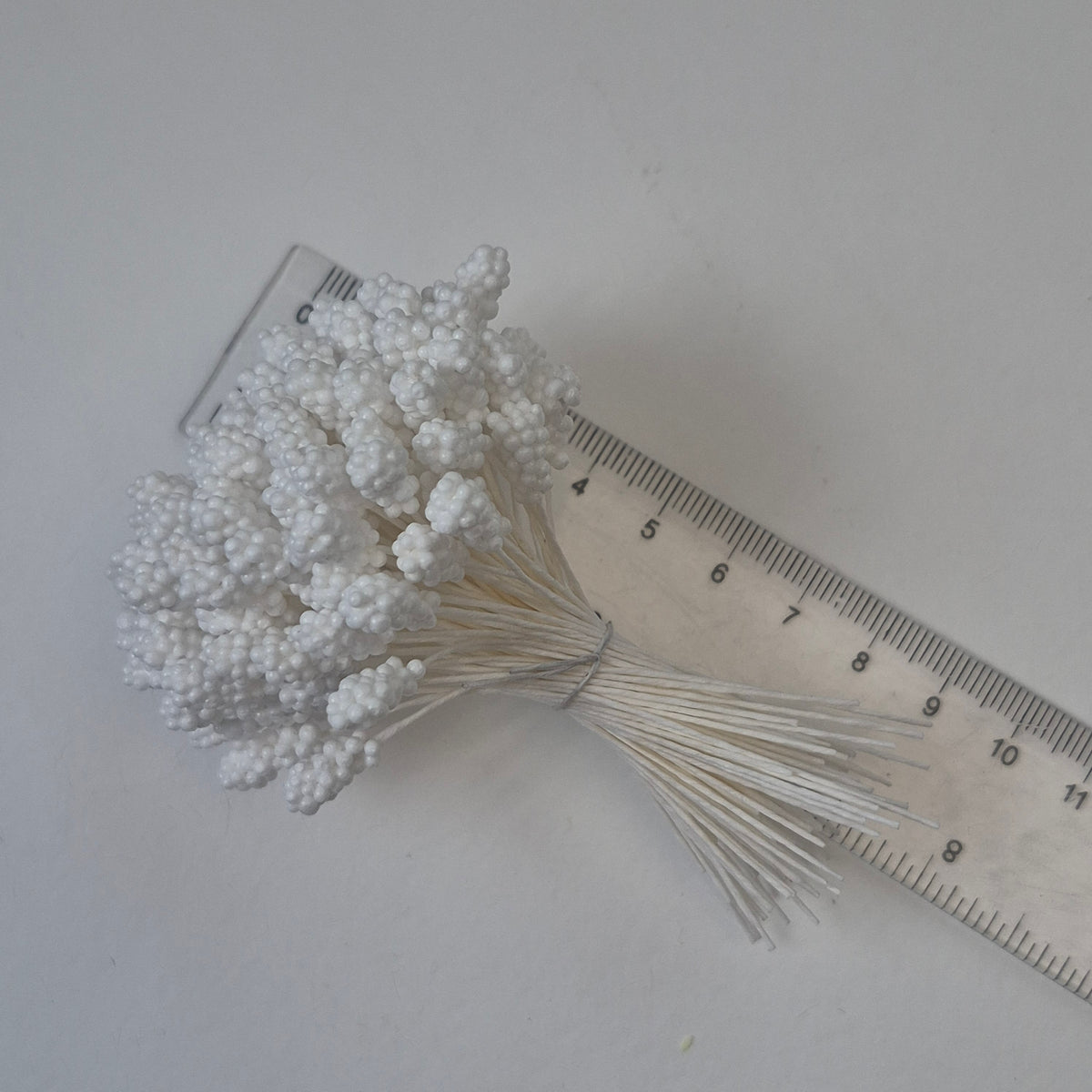 A bundle of 144 single-sided textured Japanese flower stamens with white gypsophila-effect heads on matching white rayon threads