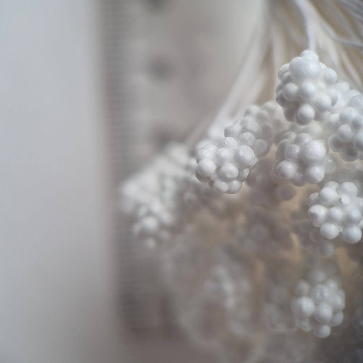 A bundle of 144 single-sided textured Japanese flower stamens with white gypsophila-effect heads on matching white rayon threads