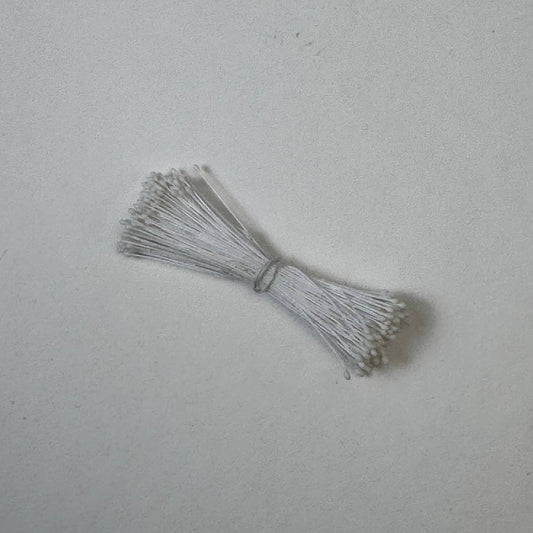 Small bundle of white round flower stamens on white cotton thread for silk floristry