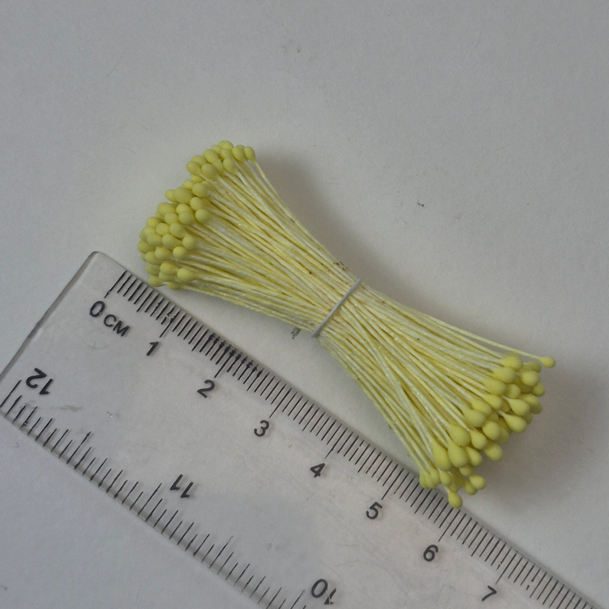 Small bundle of yellow round flower stamens on yellow cotton thread for silk floristry