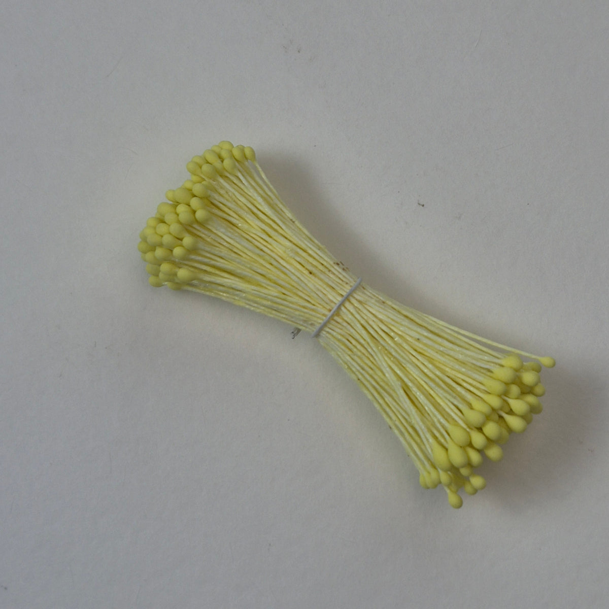 Small bundle of yellow round flower stamens on yellow cotton thread for silk floristry