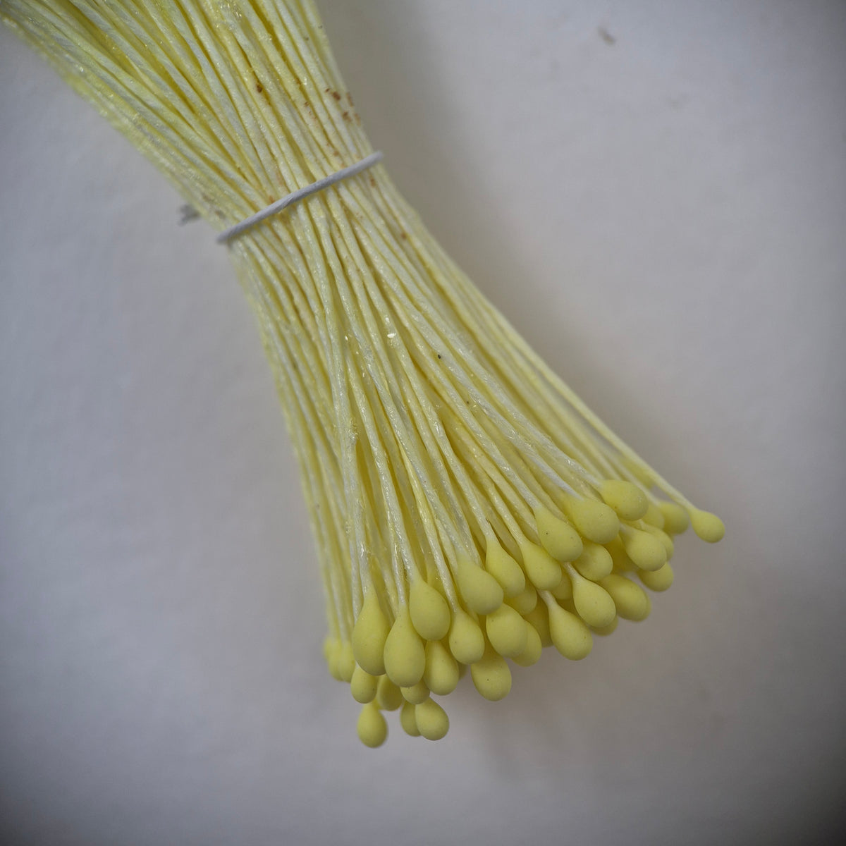 Small bundle of yellow round flower stamens on yellow cotton thread for silk floristry
