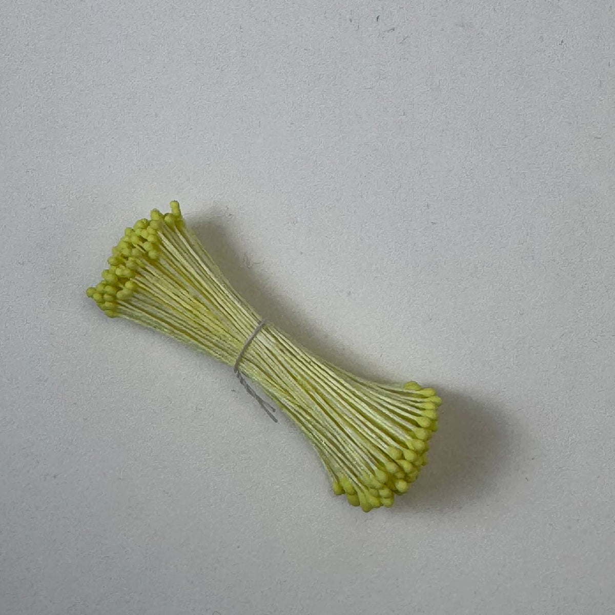 Small bundle of yellow round flower stamens on yellow cotton thread for silk floristry