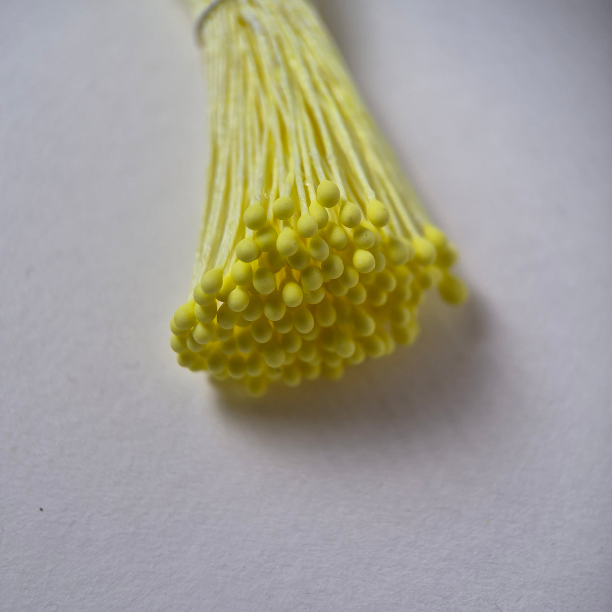 Small bundle of yellow round flower stamens on yellow cotton thread for silk floristry