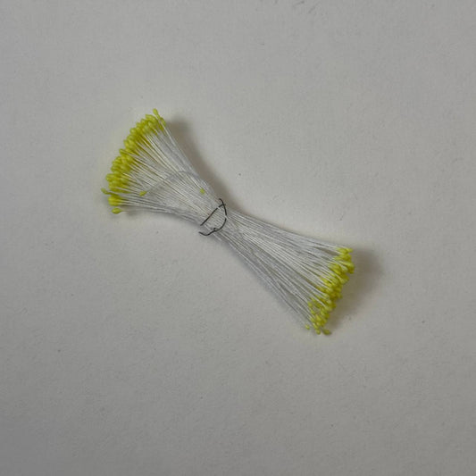 Small bundle of tiny yellow round flower stamens on snow white cotton thread for silk floristry