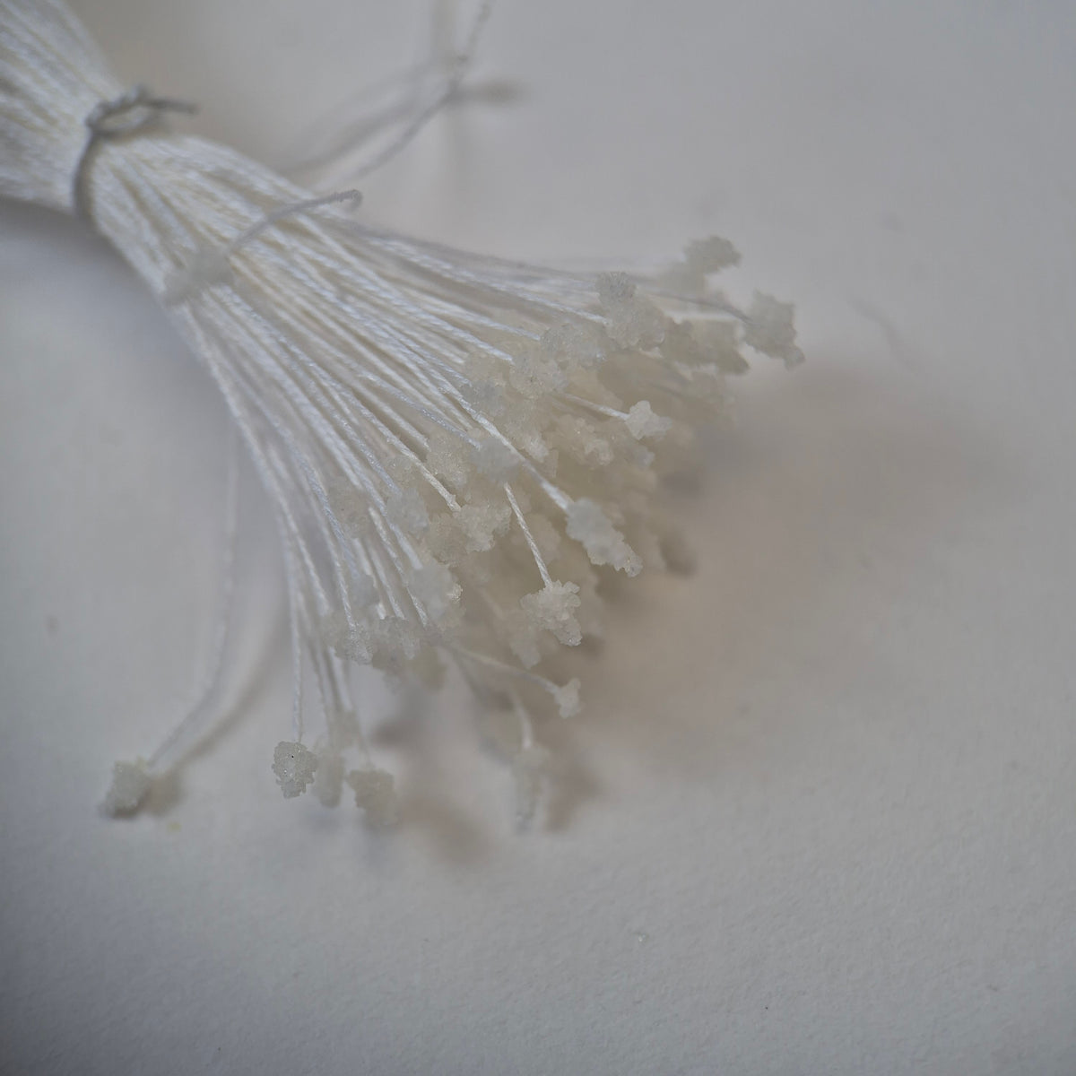 Miniature white sugar ball flower stamens size S on white cotton threads, bundle of 120 pieces